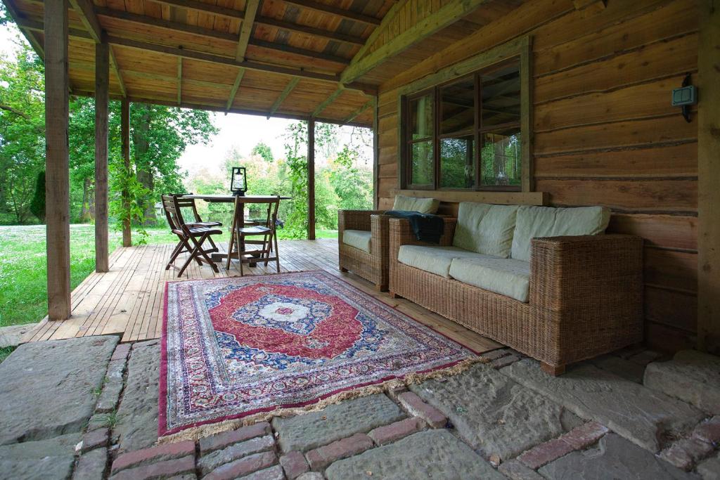a porch of a cabin with a couch and a table at Parc-Le-Breos House in Penclawdd