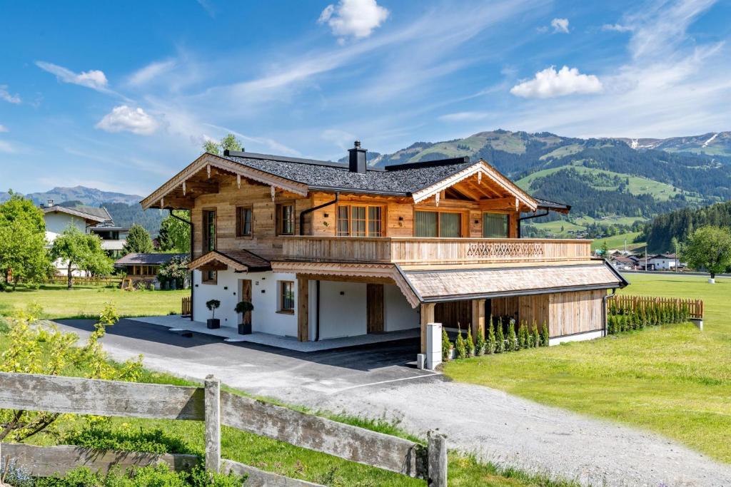 una casa en las montañas con una valla en Chalet Magdalena, en Kirchberg in Tirol