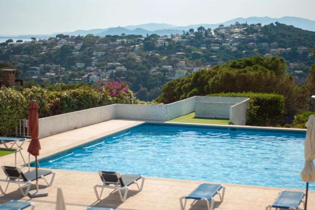 una piscina con sedie e vista sulla città di CBA COSTA BRAVA - Santa Monica a Tossa de Mar