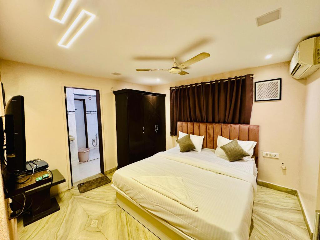 a bedroom with a large bed and a television at Hotel Elite Stay - Nilanjali Society, Kalyani Nagar, Pune in Pune