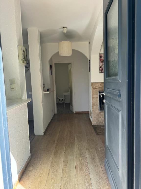 un couloir vide avec une porte bleue et une chambre dans l'établissement Maison au calme, nature et paix, à Trélissac