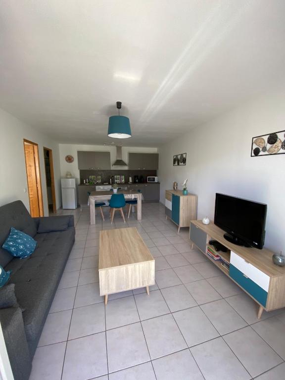 a living room with a couch and a table at Chez Virginie et Christophe in Belvédère