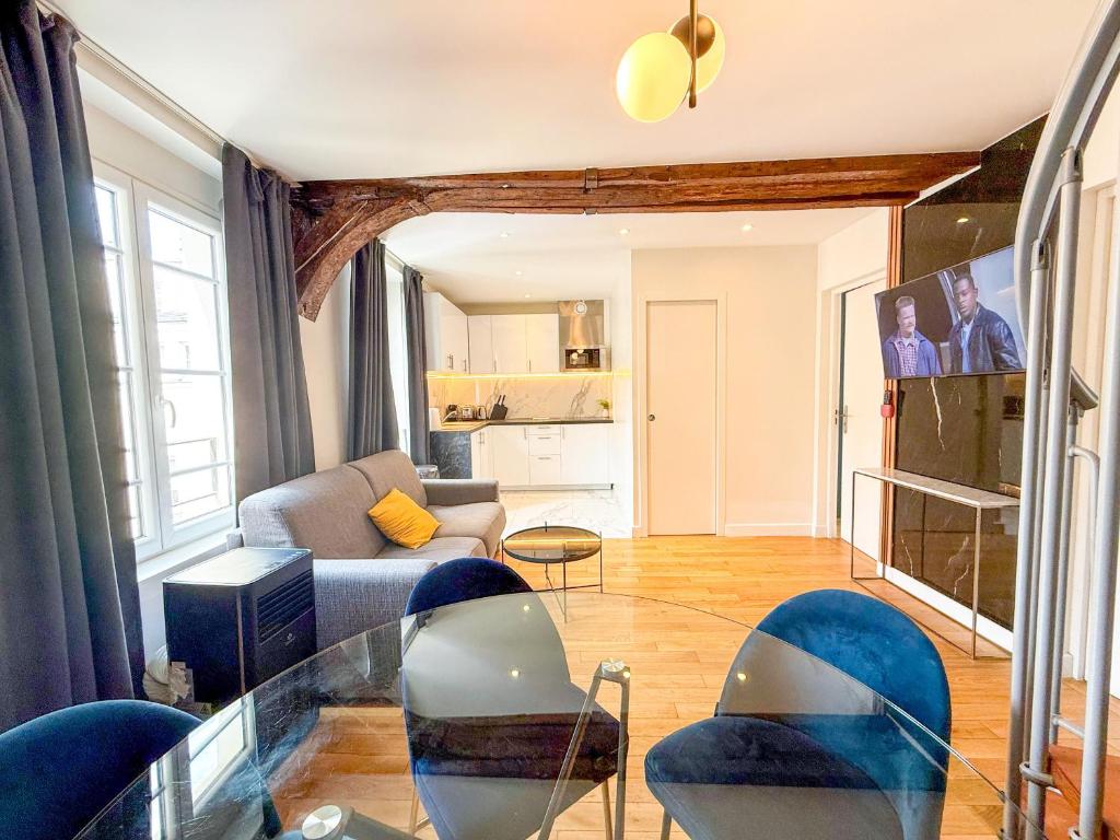 un salon avec une table en verre et des chaises dans l'établissement Urban Flat 176 - Charming 3 Bedroom in Montorgueil, à Paris
