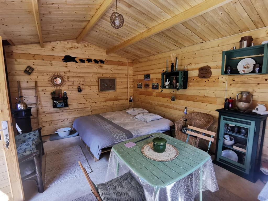 une chambre avec un lit et une table dans une pièce dans l'établissement La Bauge Ardennaise, à La Celle-sous-Gouzon