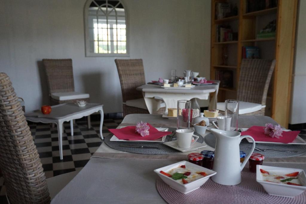 a dining room with a table with plates of food at Le Clos Saint Jean in Sainte-Honorine-des-Pertes