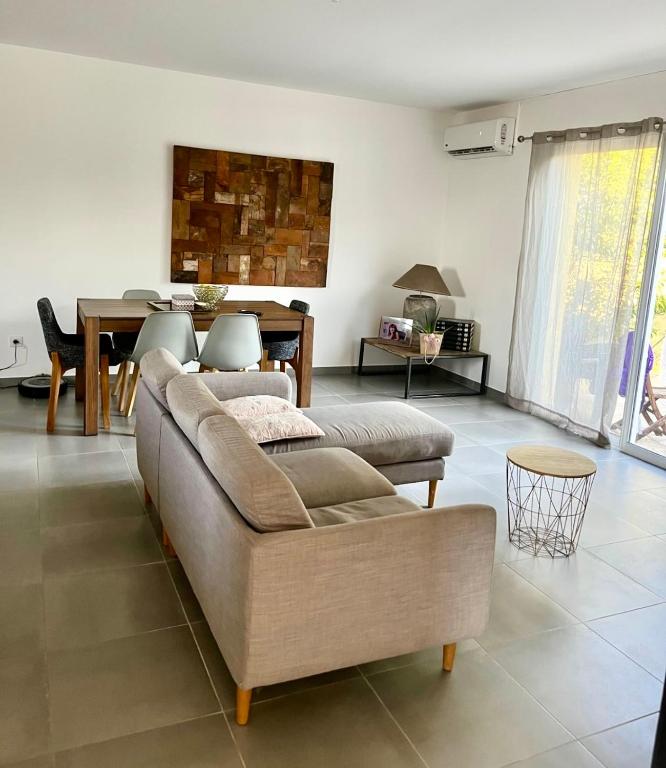 un salon avec un canapé et une table dans l'établissement Charmante Maison Mitoyenne, à Cervione