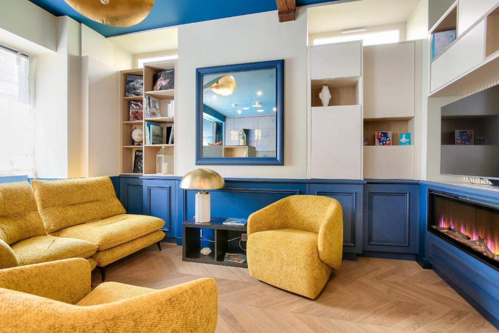 un salon avec deux chaises et une télévision dans l'établissement 300 m de la plage, terrasse, superbe maison pour 4, à Dinard