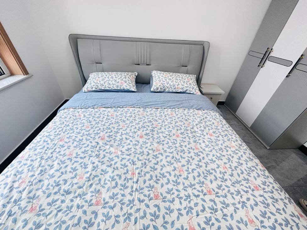 a bedroom with a bed with a blue and pink comforter at Little Room in Ruakura Junction