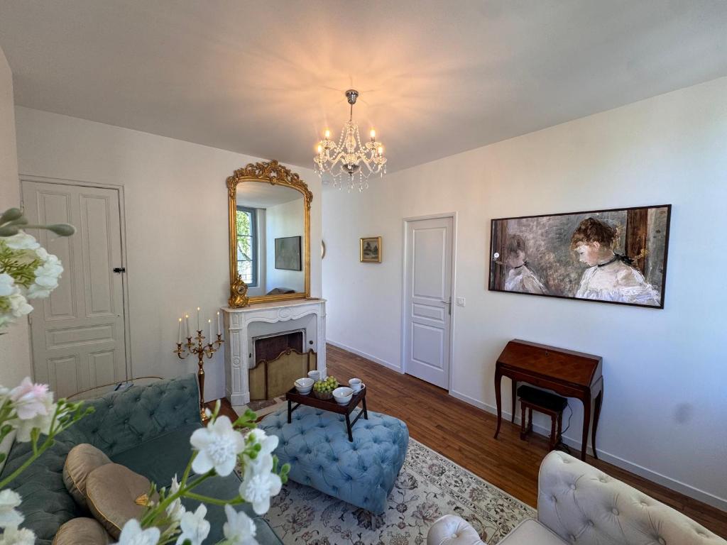 a living room with a blue couch and a mirror at La Cour des Murmures - Logis central d'exception - in Troyes
