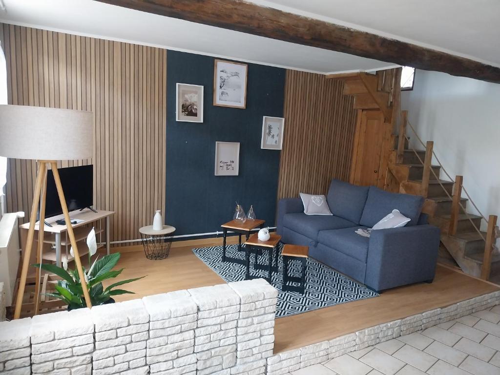 - un salon avec un canapé bleu et un escalier dans l'établissement maison beauval, à La Celle-sous-Gouzon