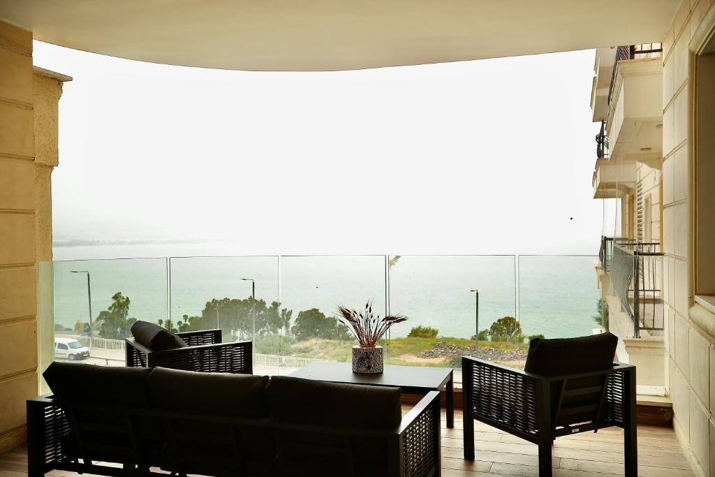 a room with a table and chairs and a view of the ocean at אירופה בוטיק כנרת - דירת 4 חדרי שינה עם נוף לכנרת in Tiberias