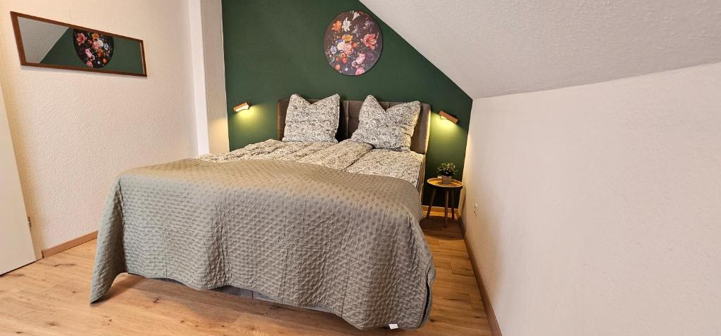 una camera da letto con un letto e una parete verde di Dimi Living Oberhausen & mit Küche a Oberhausen