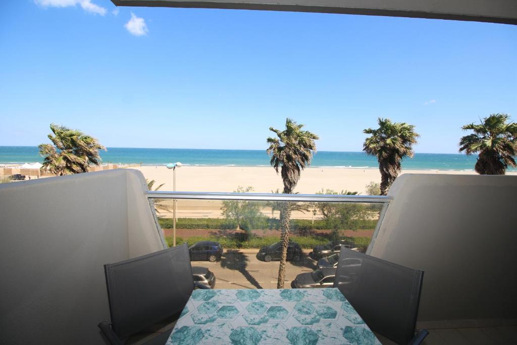 - un balcon avec une table et des chaises offrant une vue sur la plage dans l'établissement Appartement 2 chambres vue mer, à Canet