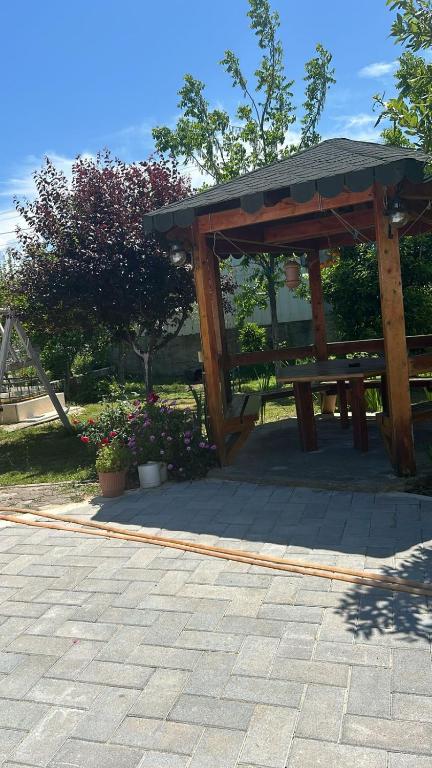a wooden picnic table in a park with flowers at Dhoma Pushimi Tale Beach in Lezhë