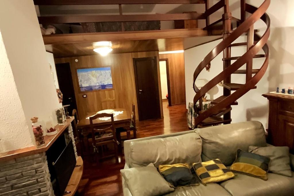 Sauze d'OulxにあるSauze D'Oulx Penthouse Apartmentのソファと螺旋階段のあるリビングルーム