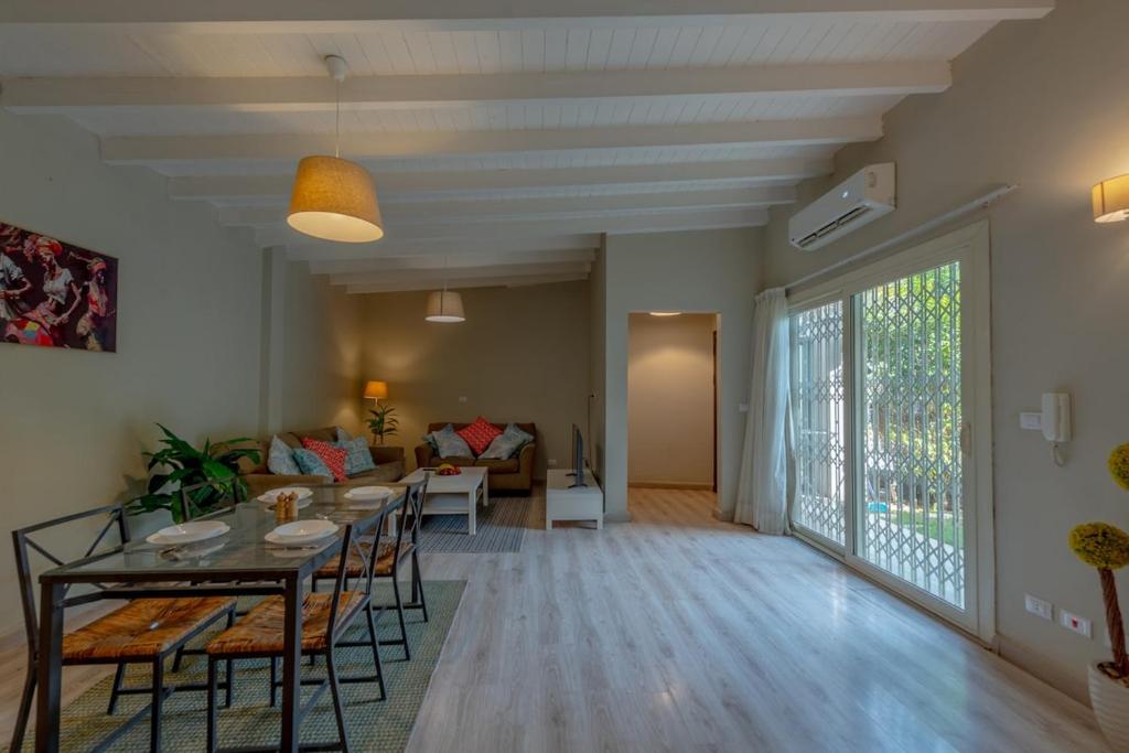 a living room with a table and chairs and a couch at Luxury Villa with private garden in Cairo