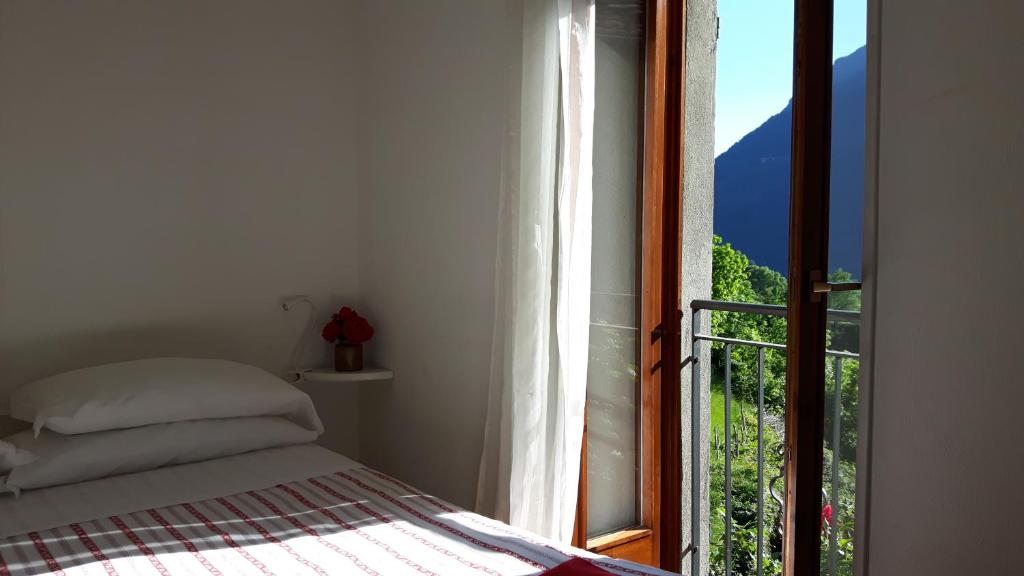 a bedroom with a bed and an open window at La Turr De Mezz in Nesso