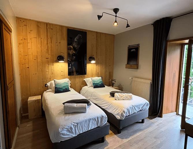 une chambre avec deux lits dans une pièce dans l'établissement L'auberge de Mégevette, à Mégevette