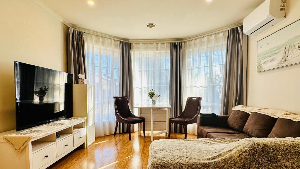 un soggiorno con divano e TV a schermo piatto di 20 minutes to Mel CBD 2 BRs AirCon unit guest house a Laverton