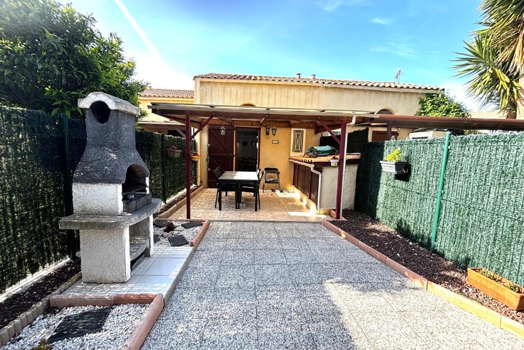une maison avec un portail et une passerelle en pierre dans l'établissement Le Hameau - Proche plage - Piscine - Parking, à Saint-Cyprien