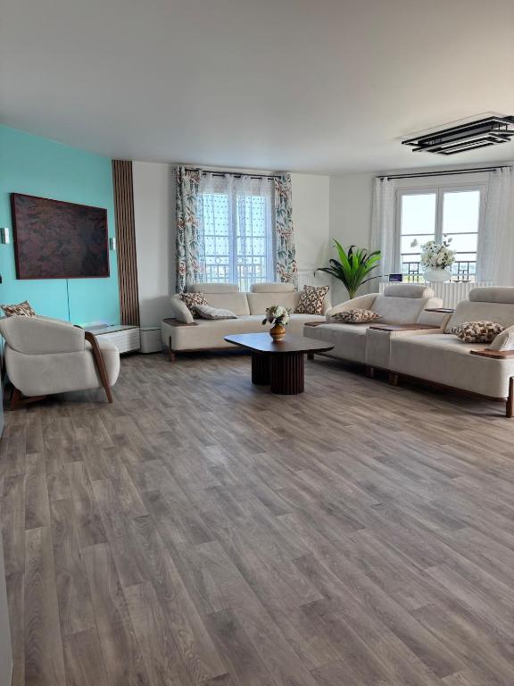 un grand salon avec des canapés et une table dans l'établissement Duplex spacieux, au Blanc-Mesnil