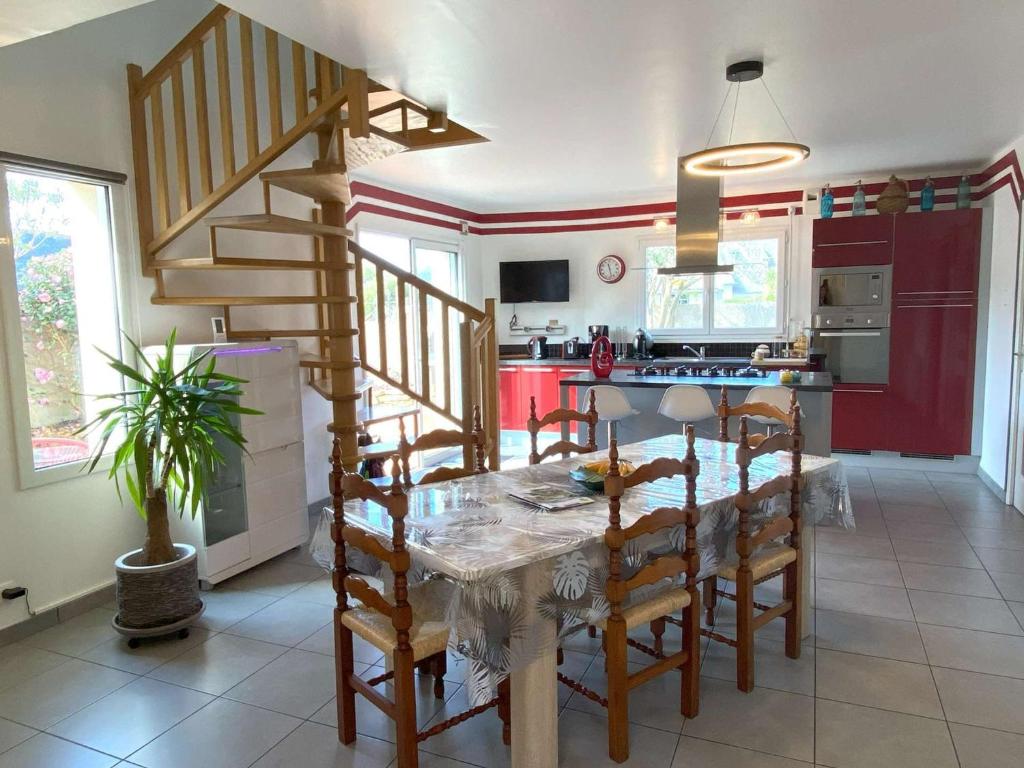 une cuisine et une salle à manger avec une table et des chaises dans l'établissement Maison avec WIFI, jardin clos et terrasse, à 500m de la mer et du GR34, Île Grande - FR-1-368-13, à Pleumeur-Bodou