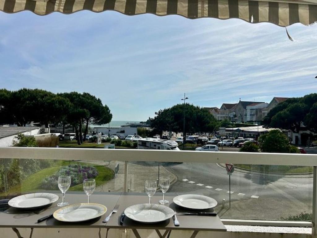 a table with wine glasses and a view of a street at Appartement 3 pièces proche de la plage avec parking - FR-1-494-146 in Royan