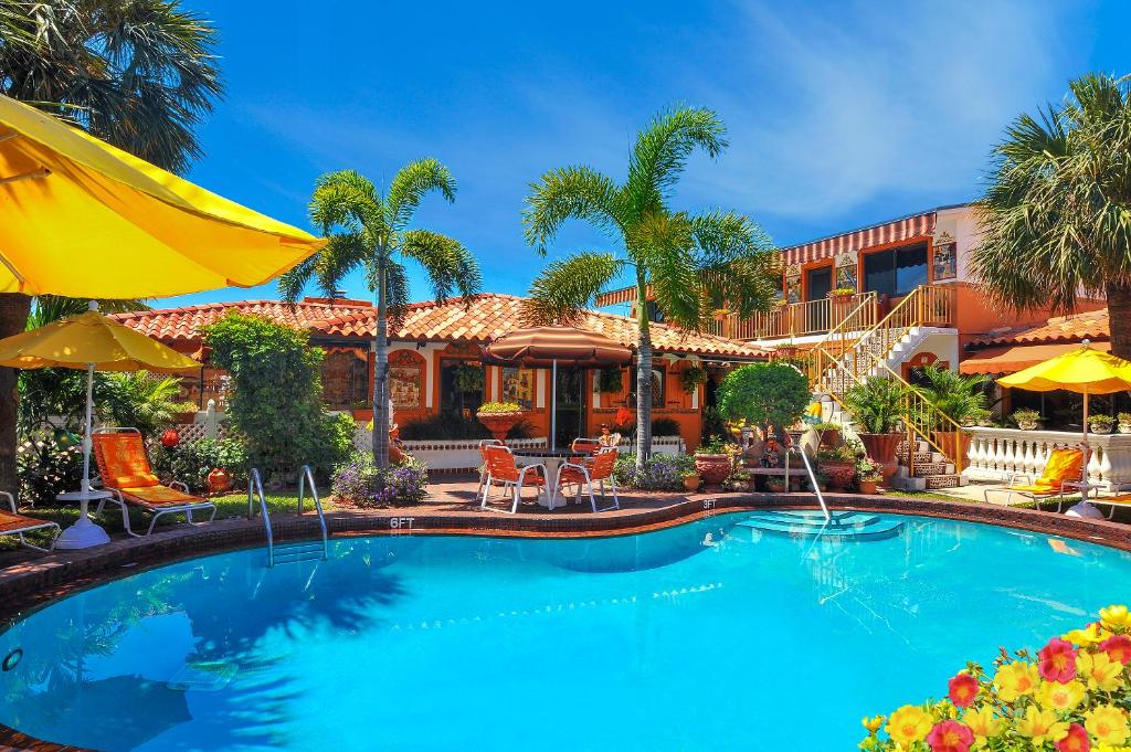 una piscina frente a una casa con palmeras en Blue Seas Courtyard, en Fort Lauderdale