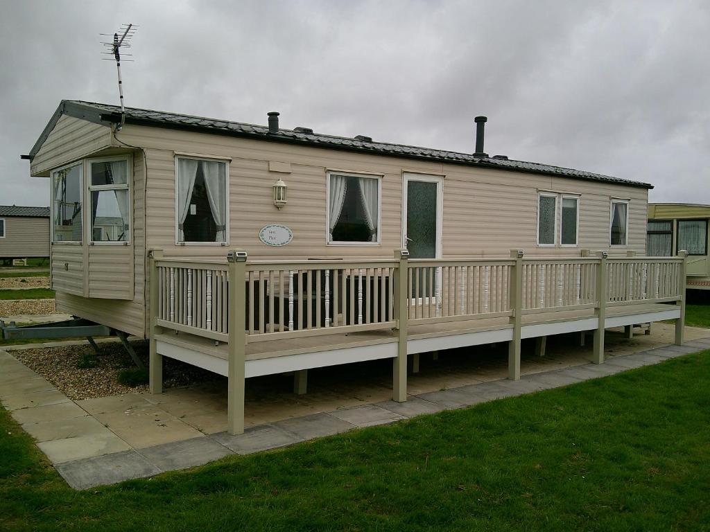 a mobile home with a porch and a deck at Eastgate Richmond 8 Berth Blow Heated Free WIFI in Ingoldmells