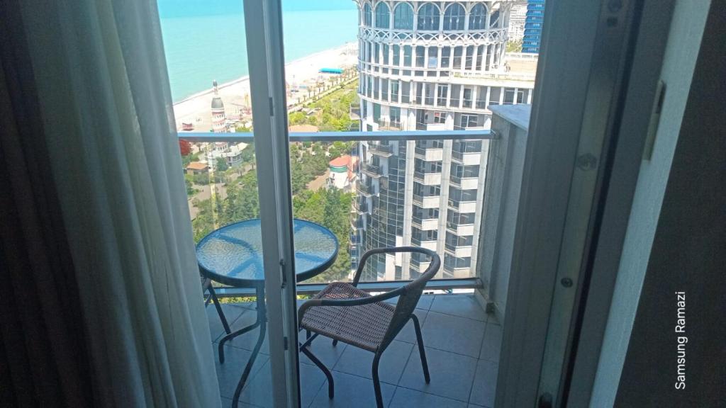 a balcony with a table and chairs and a view of the ocean at Sea Star 2 in Batumi