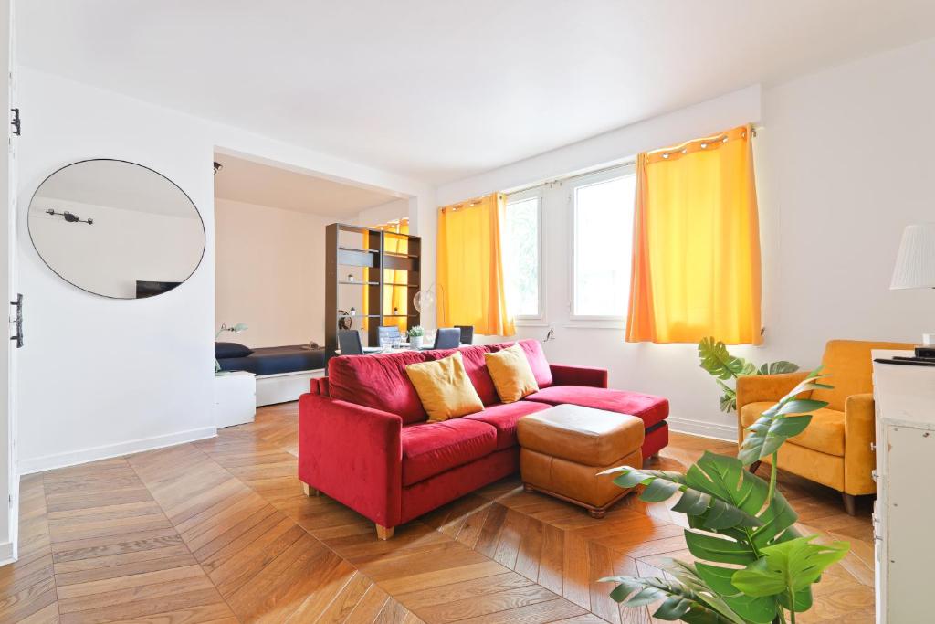 - un salon avec un canapé rouge et des rideaux jaunes dans l'établissement Heart of Paris-Studio-Hotel des Invalides Netflix, à Paris