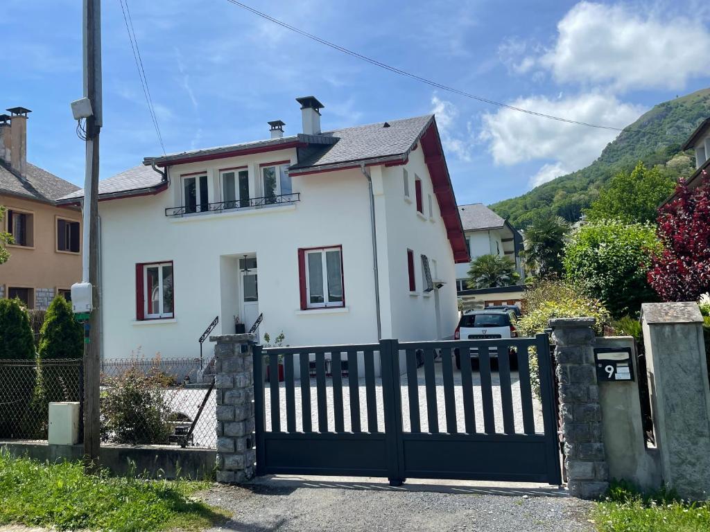 een wit huis met een hek ervoor bij Grande maison dans les Pyrénées in Argelès-Gazost