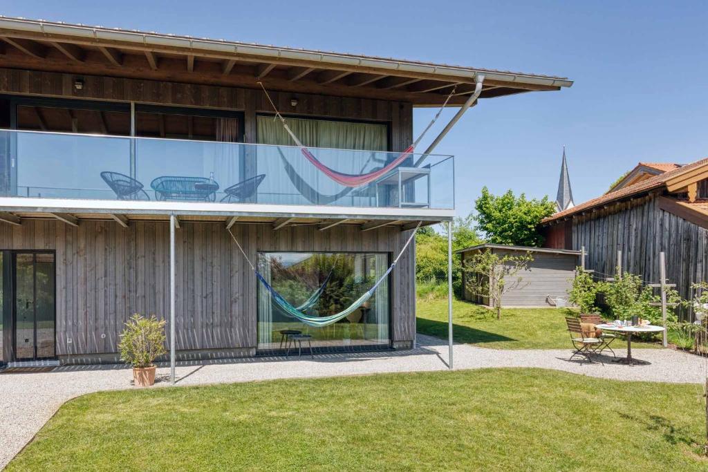 ein Haus mit einer Hängematte, die seitlich hängt in der Unterkunft LIEBLINGSECK nachhaltige 5-Sterne Ferienwohnung direkt am Chiemsee in Gstadt am Chiemsee