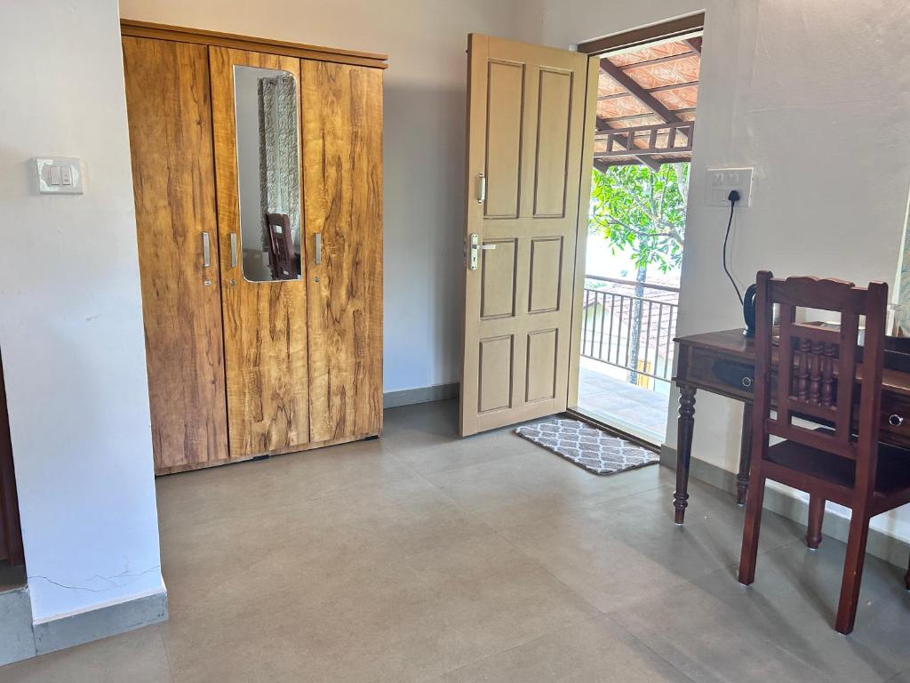 a room with a door and a desk and a window at Heritage Farm Kerala in Idukki