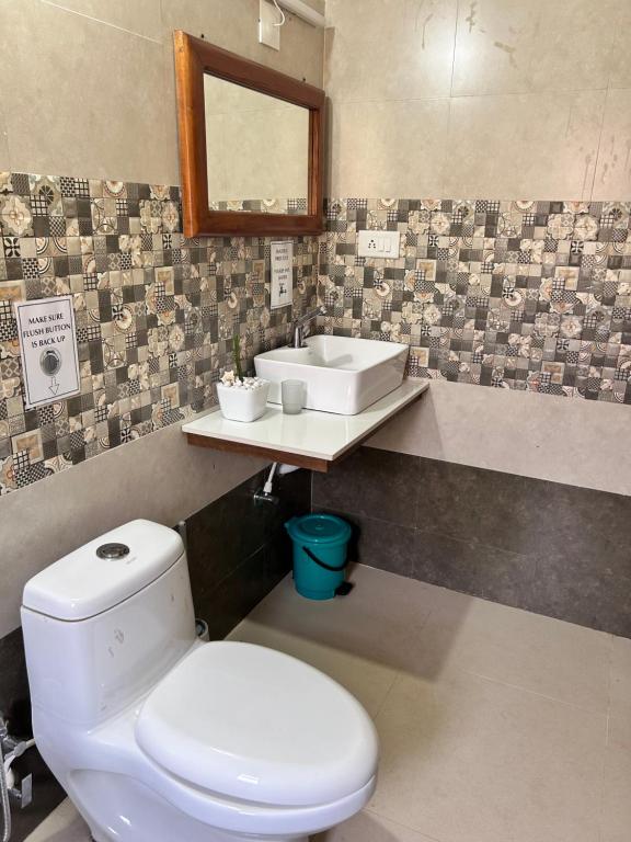 a bathroom with a white toilet and a sink at Heritage Farm Kerala in Idukki