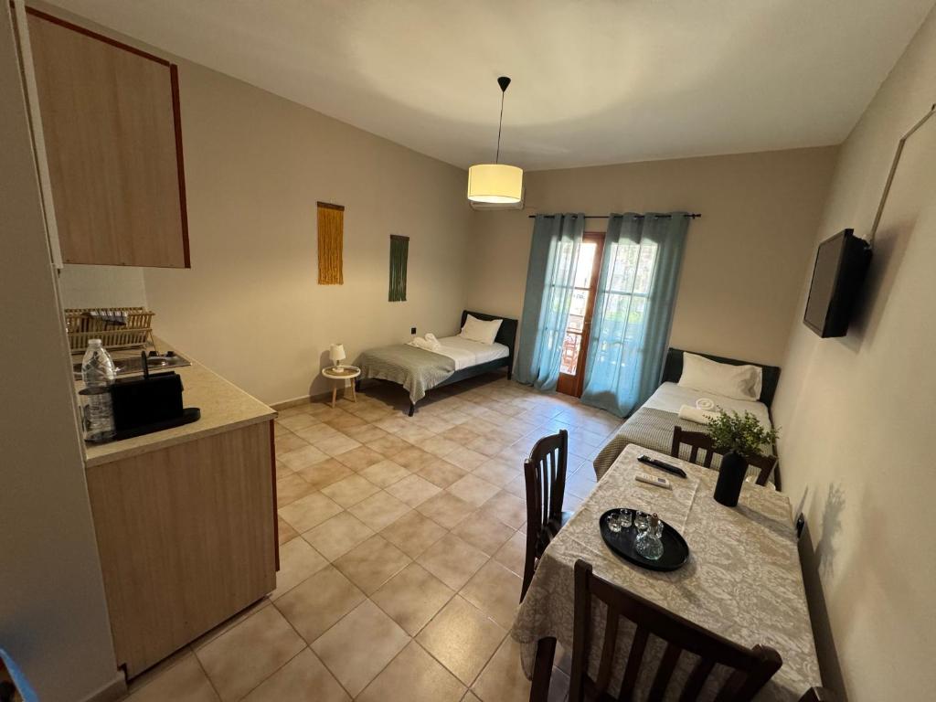 a kitchen and living room with a table and a couch at Nicolas Beach in Palaiochora