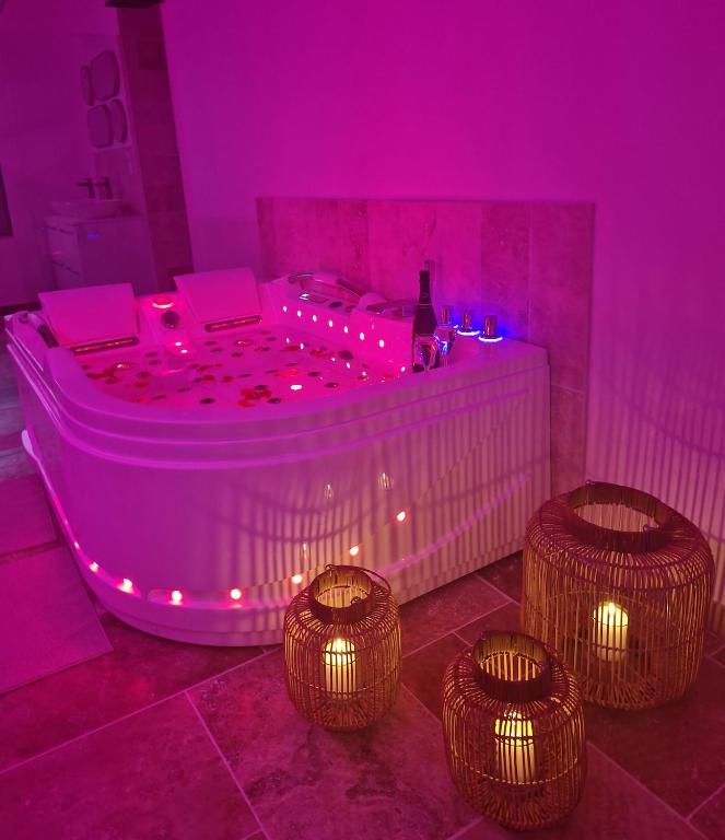 une chambre violette avec un jacuzzi à trois lumières dans l'établissement L'audacieuse-Jacuzzi et sauna , miroir suspendu, à Veuzain-sur-Loire