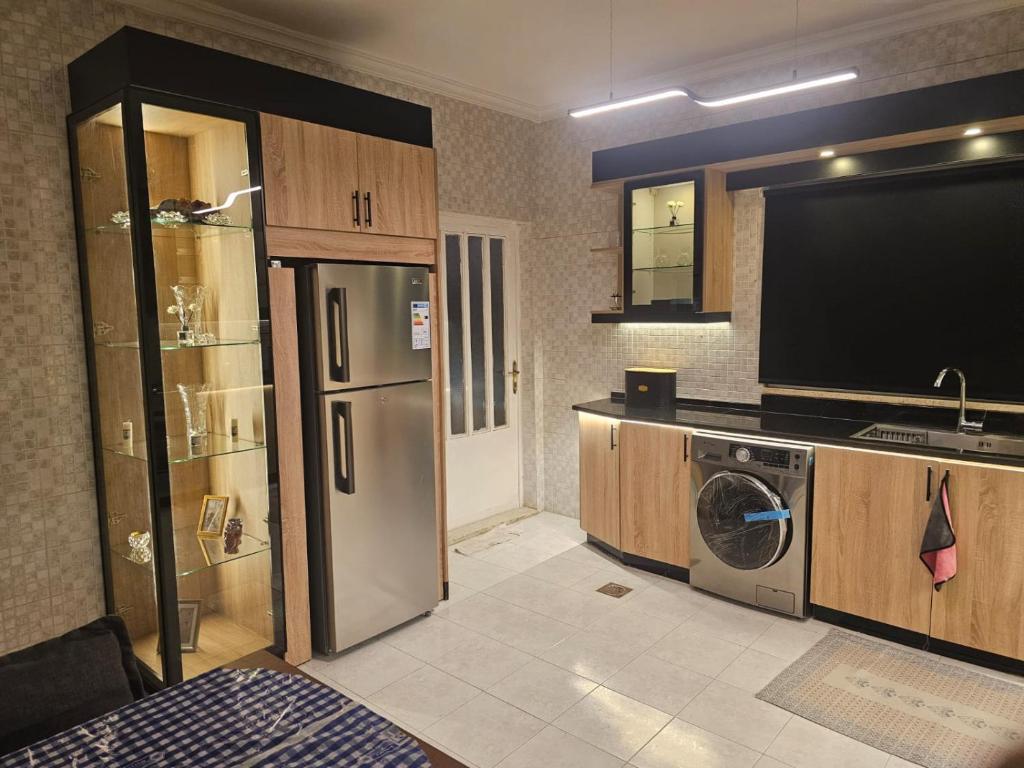 cocina con TV, lavadora y secadora en شقة 3غرف نوم في ضاحية الرشيد, en Amán