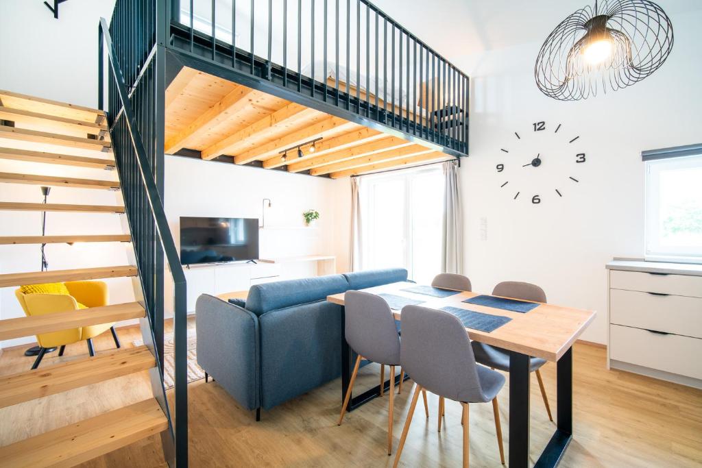 a kitchen and dining room with a staircase and a table and chairs at Pálava Lake Apartments in Pasohlávky