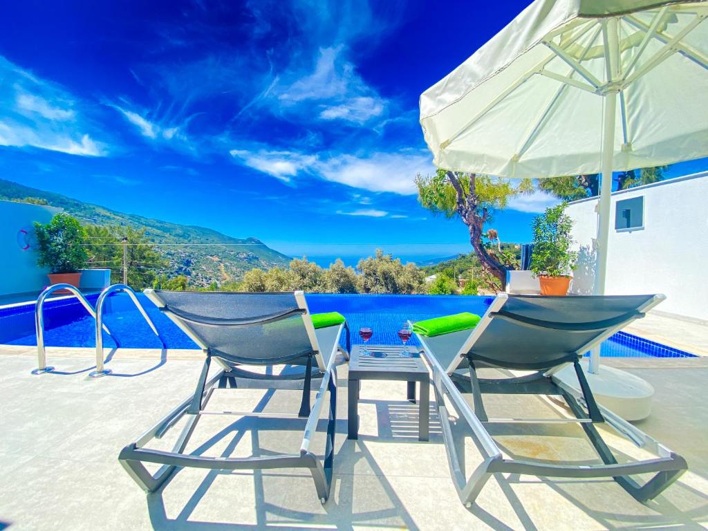 eine Terrasse mit zwei Stühlen und einem Sonnenschirm in der Unterkunft Villa Irmak İslamlar in Kaş