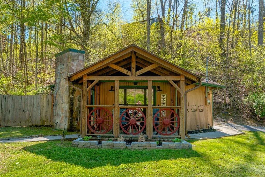 ein kleiner Schuppen mit roten Rädern in einem Hof in der Unterkunft Pet friendly, hottub, sleeps 4, flat roads, GBurg! in Gatlinburg