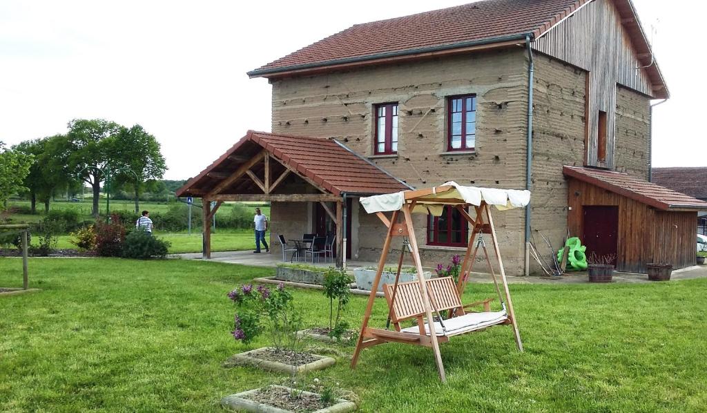 eine Schaukel in einem Hof vor einem Haus in der Unterkunft Maison d'hôtes La Tuilerie in Peschadoires