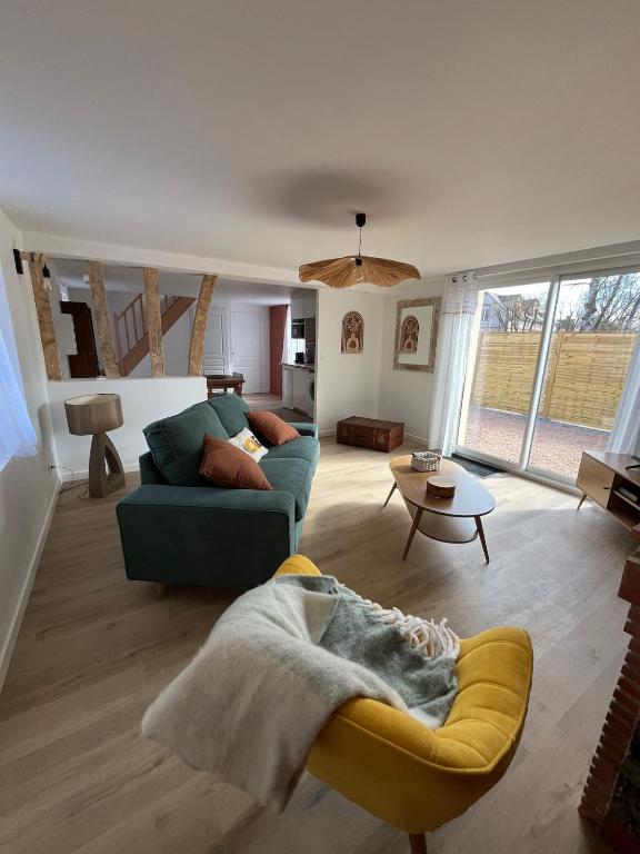 un salon avec un canapé bleu et une table dans l'établissement Chez Colette- Maison avec jardin, à Acquigny