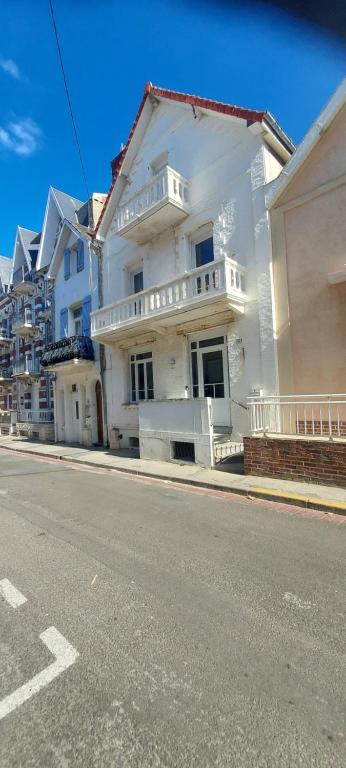 une maison blanche sur le côté d'une rue dans l'établissement Maison avec vue mer, à Berck-sur-Mer