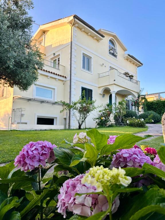 a large house with flowers in front of it at Villa Luce B&B in Olbia
