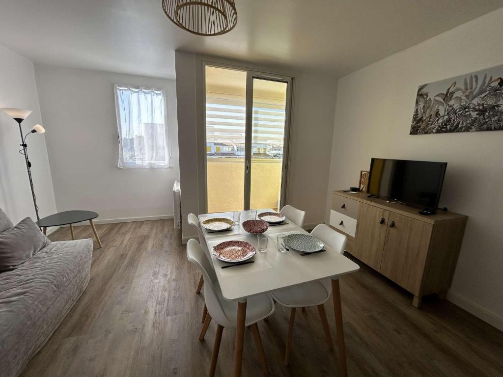 un salon avec une table et une télévision dans l'établissement Appartement rénové 2 pièces avec balcon, à 200m de la plage, St Hilaire de Riez - FR-1-224C-318, à Saint-Hilaire-de-Riez