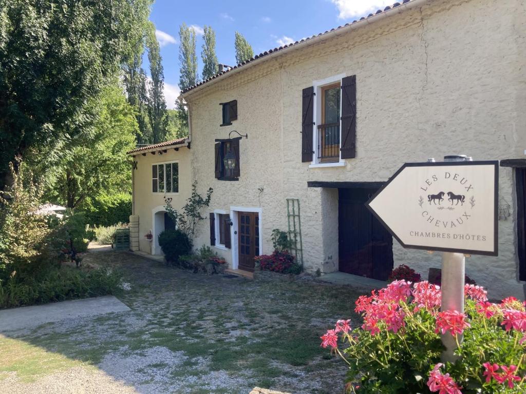 una casa con un cartello davanti di Les Deux Chevaux Chambres d’Hôtes a Rouvenac