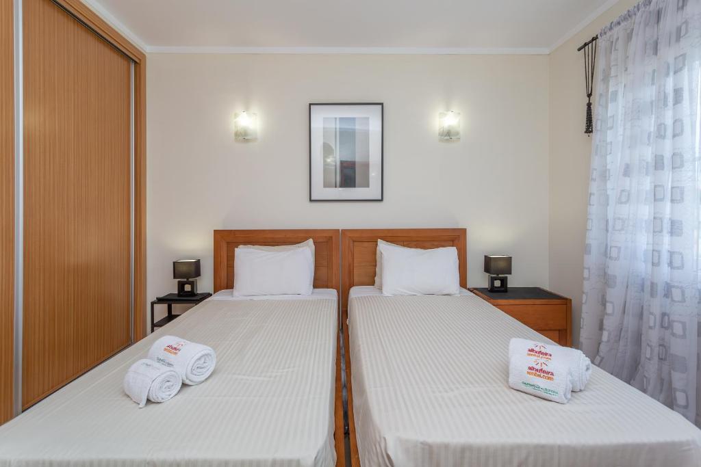 a bedroom with two beds with towels on them at Glenridge Resort By Albufeira Rental in Albufeira