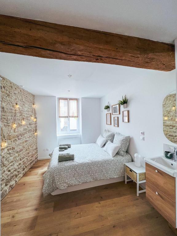 une chambre avec un lit et un mur de briques dans l'établissement Escapade Chambertine au cœur de Gevrey-Chambertin, à Gevrey-Chambertin