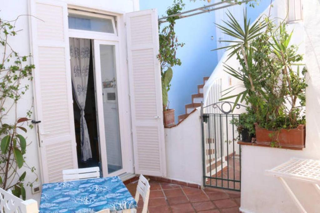 a small balcony with a table and some plants at La Casa del Comandante in Ponza